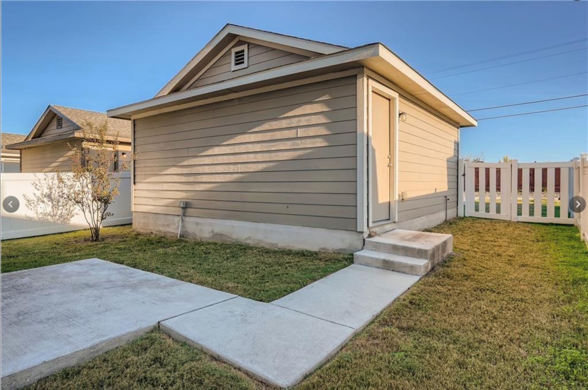 304 Cane River Road Pflugerville, TX 78660 - Photo 27 of 31 A well-maintained side yard features a sturdy fence, concrete pathways, and an accessible side entrance.