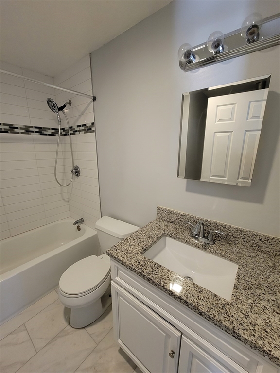 7 Gibbs Street, Unit 7 Worcester, MA 01607 - Photo 11 of 20 a bathroom with a granite countertop sink a toilet and shower