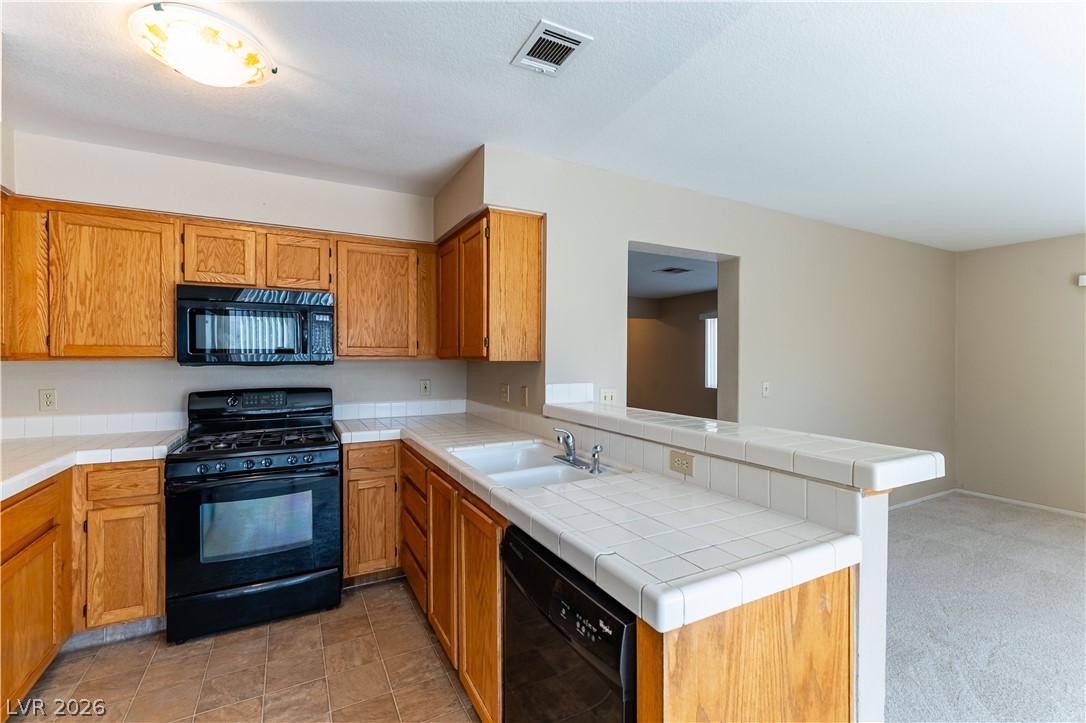 2657 Storey Circle Henderson, NV 89074 - Photo 4 of 12 This functional kitchen features ample cabinet space, a gas range, and a breakfast bar.