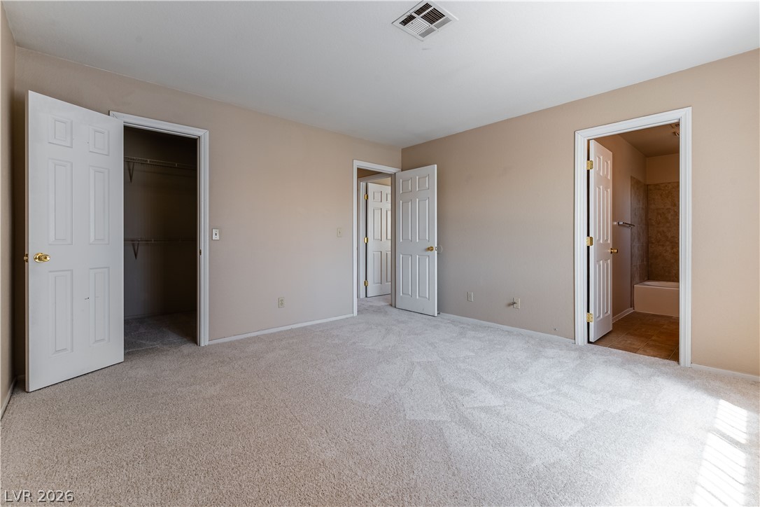 2657 Storey Circle Henderson, NV 89074 - Photo 8 of 12 This spacious bedroom offers comfortable carpeting and convenient access to a walk-in closet and a private bathroom.