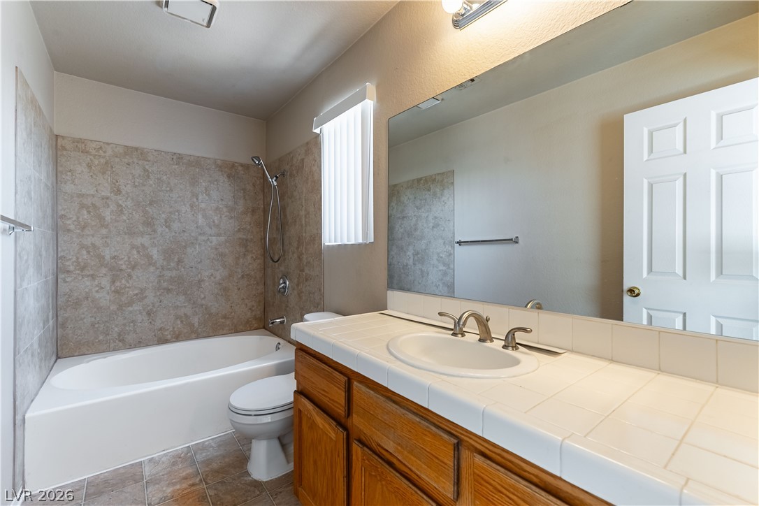 2657 Storey Circle Henderson, NV 89074 - Photo 9 of 12 This functional bathroom offers a tiled shower and vanity with a spacious mirror.