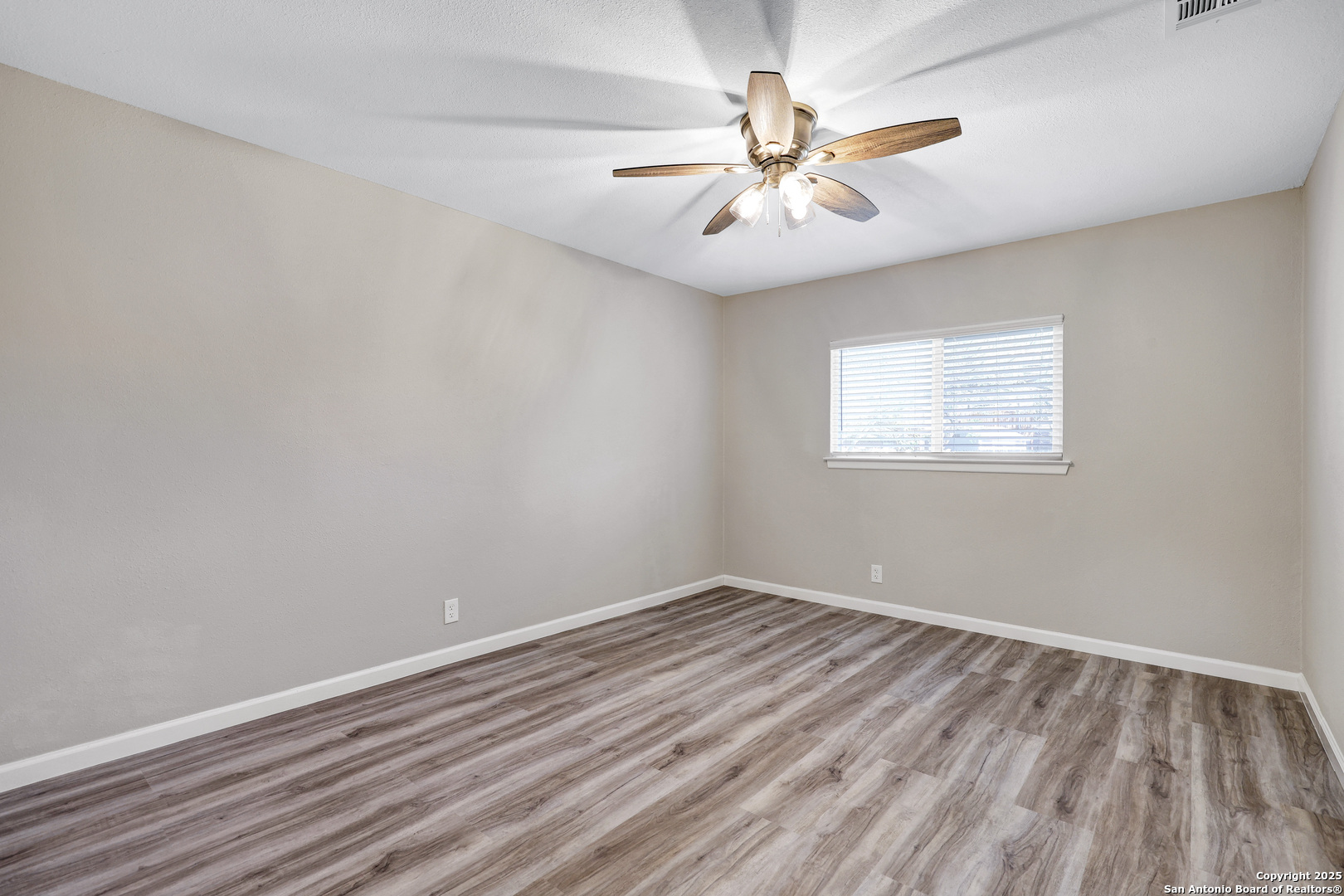 7103 Spring Point Street San Antonio, TX 78249 - Photo 11 of 28 an empty room with a window and a fan