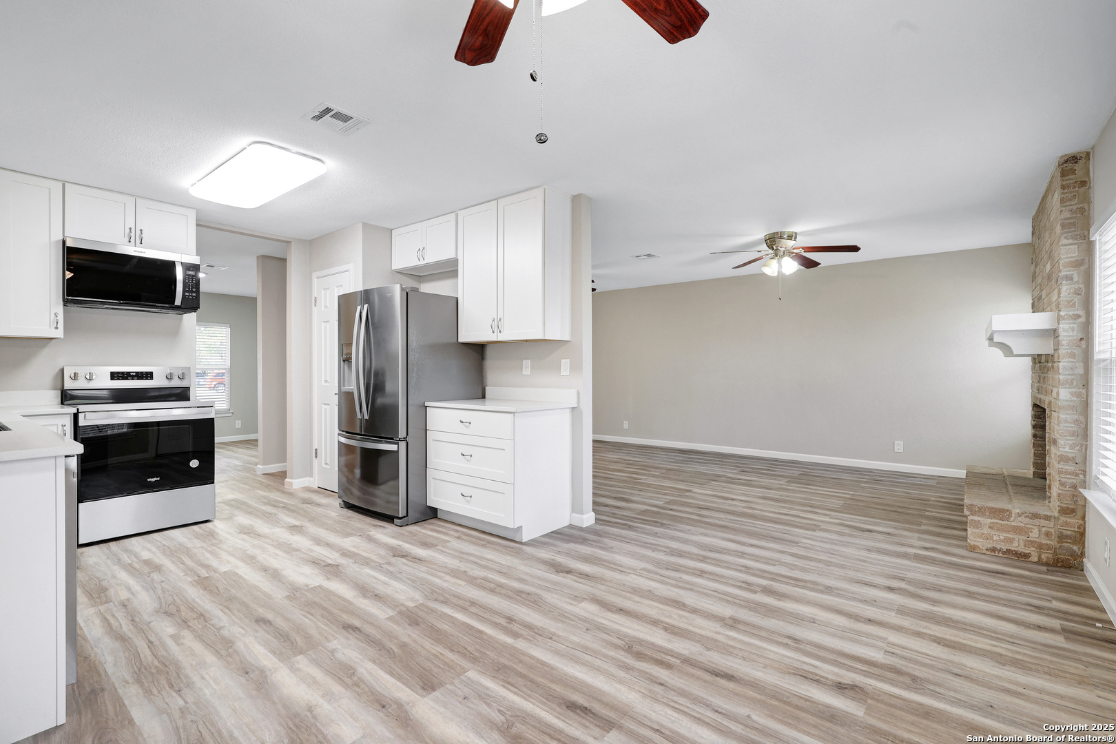 7103 Spring Point Street San Antonio, TX 78249 - Photo 14 of 28 a kitchen with stainless steel appliances kitchen island granite countertop a refrigerator and a stove