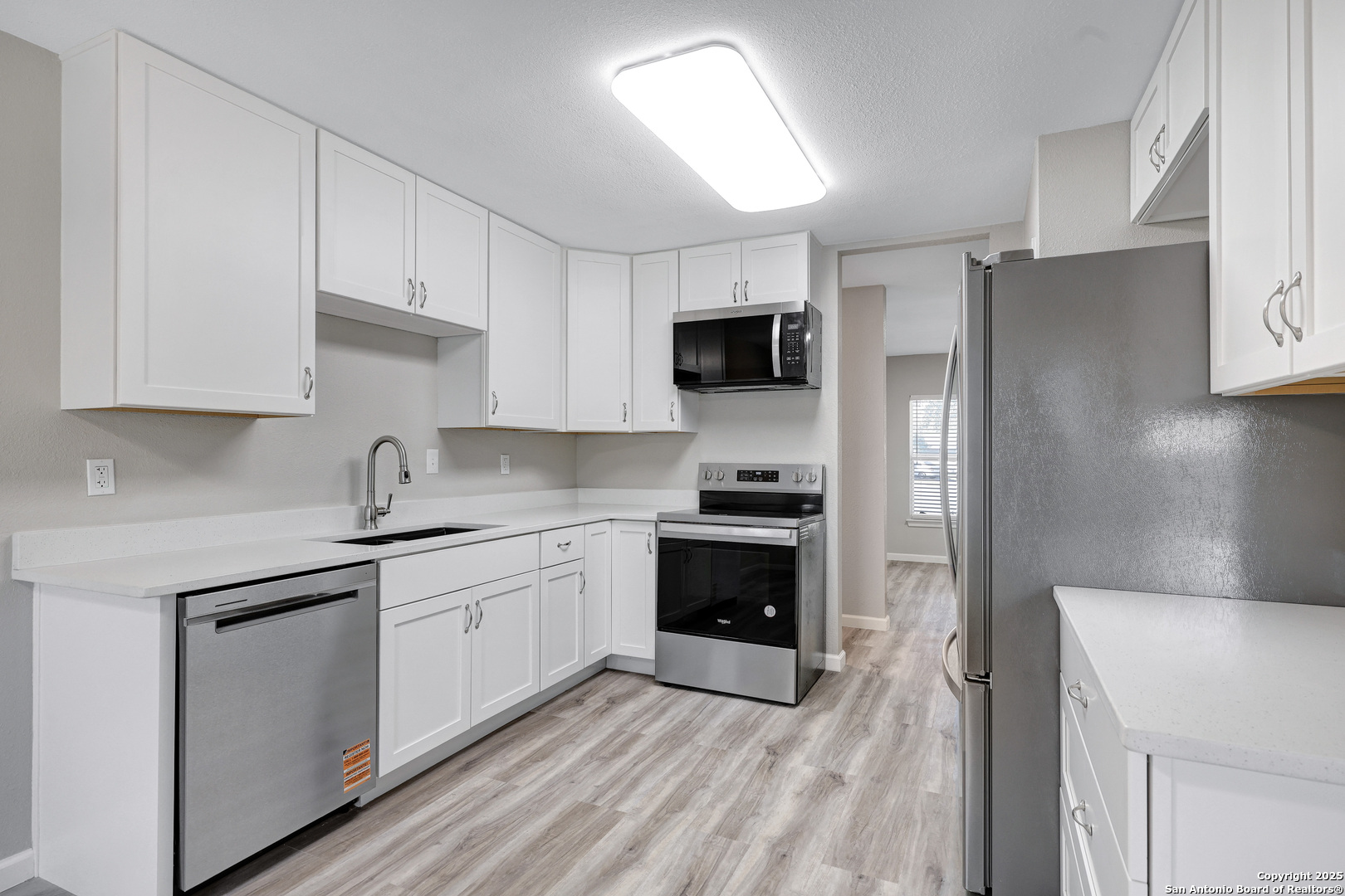 7103 Spring Point Street San Antonio, TX 78249 - Photo 16 of 28 a kitchen with a sink a stove and refrigerator