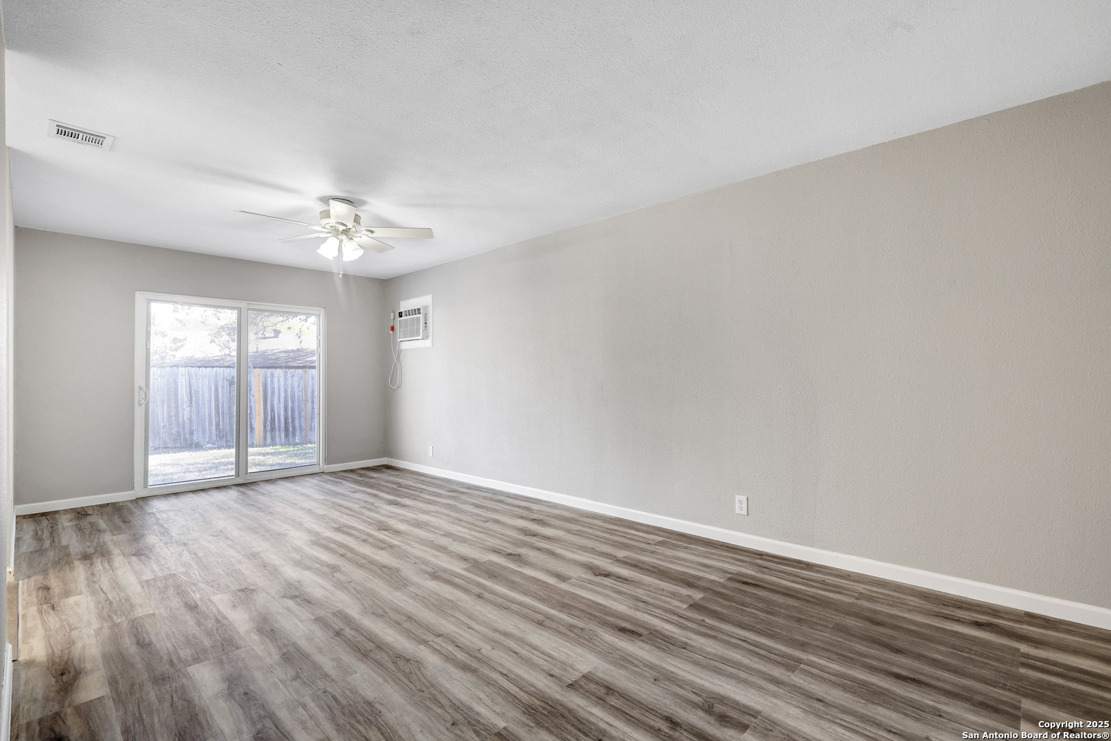 7103 Spring Point Street San Antonio, TX 78249 - Photo 18 of 28 a view of an empty room with window and wooden floor