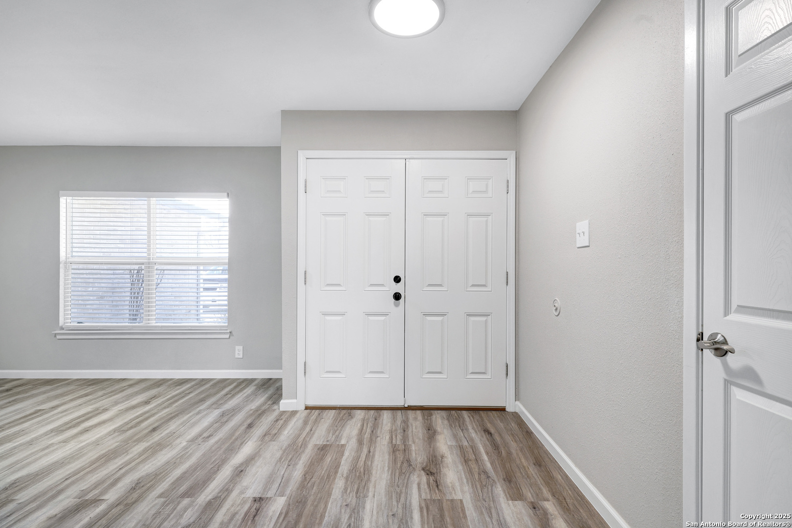 7103 Spring Point Street San Antonio, TX 78249 - Photo 2 of 28 an empty room with wooden floor and windows