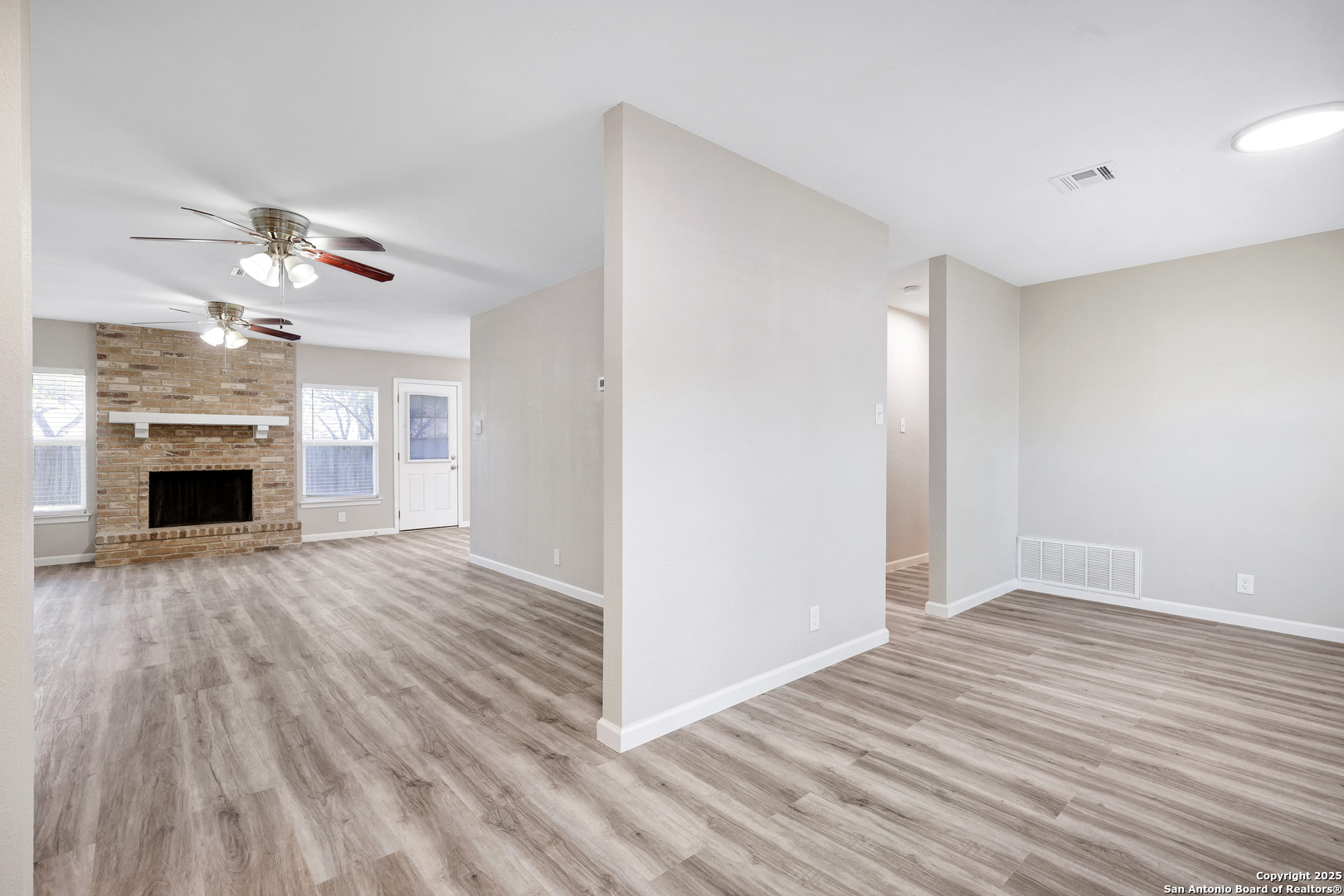 7103 Spring Point Street San Antonio, TX 78249 - Photo 5 of 28 a view of a livingroom with a fireplace a ceiling fan and wooden floor