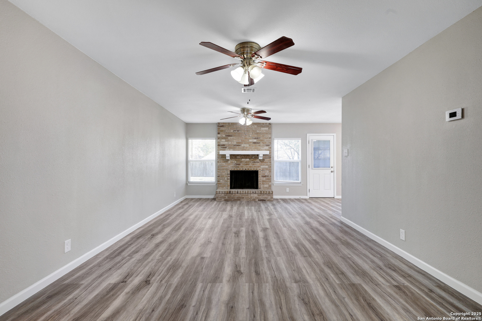 7103 Spring Point Street San Antonio, TX 78249 - Photo 8 of 28 wooden floor in an empty room with a window