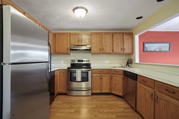 a kitchen with stainless steel appliances granite countertop a refrigerator sink and stove