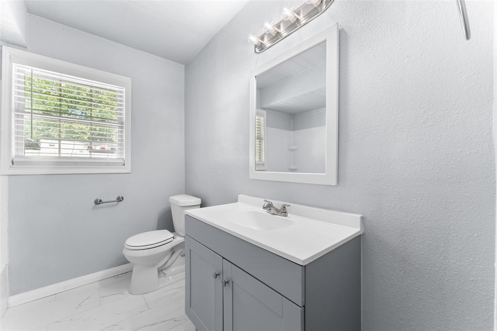 612 East 8th Street Kemp, TX 75143 - Photo 19 of 25 Bathroom featuring a single vanity with a gray cabinet, white countertop with integrated sink, and an overhead vanity light