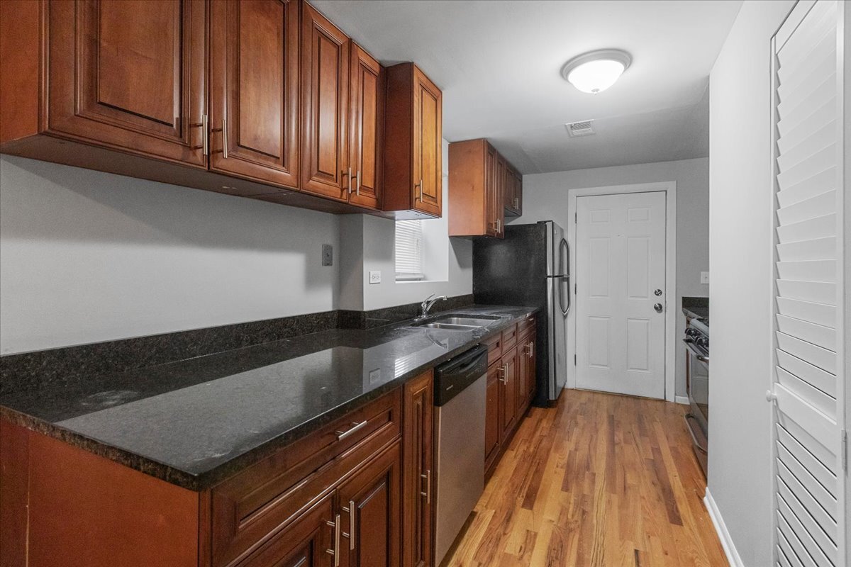 1464 West Ohio Street, Unit 1F Chicago, IL 60642 - Photo 3 of 10 a kitchen with granite countertop stainless steel appliances a stove top oven a sink and dishwasher with wooden floor
