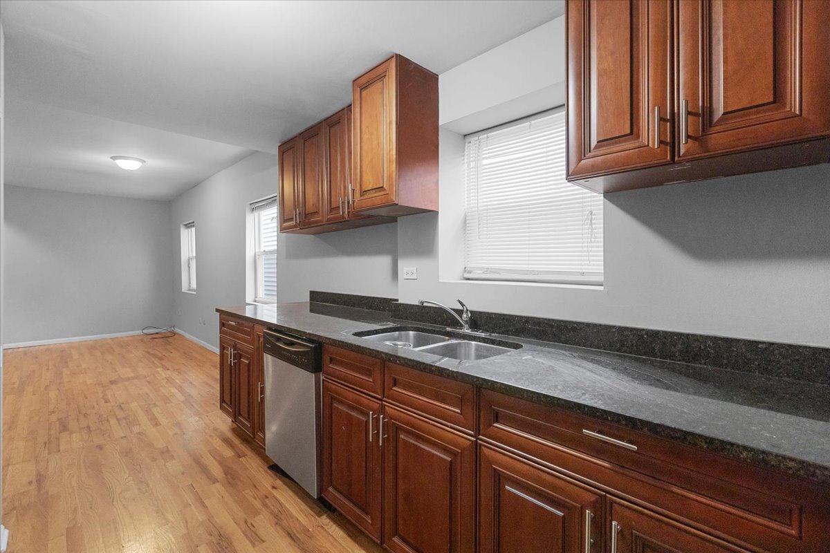 1464 West Ohio Street, Unit 1F Chicago, IL 60642 - Photo 4 of 10 a kitchen with granite countertop stainless steel appliances a sink window and cabinets