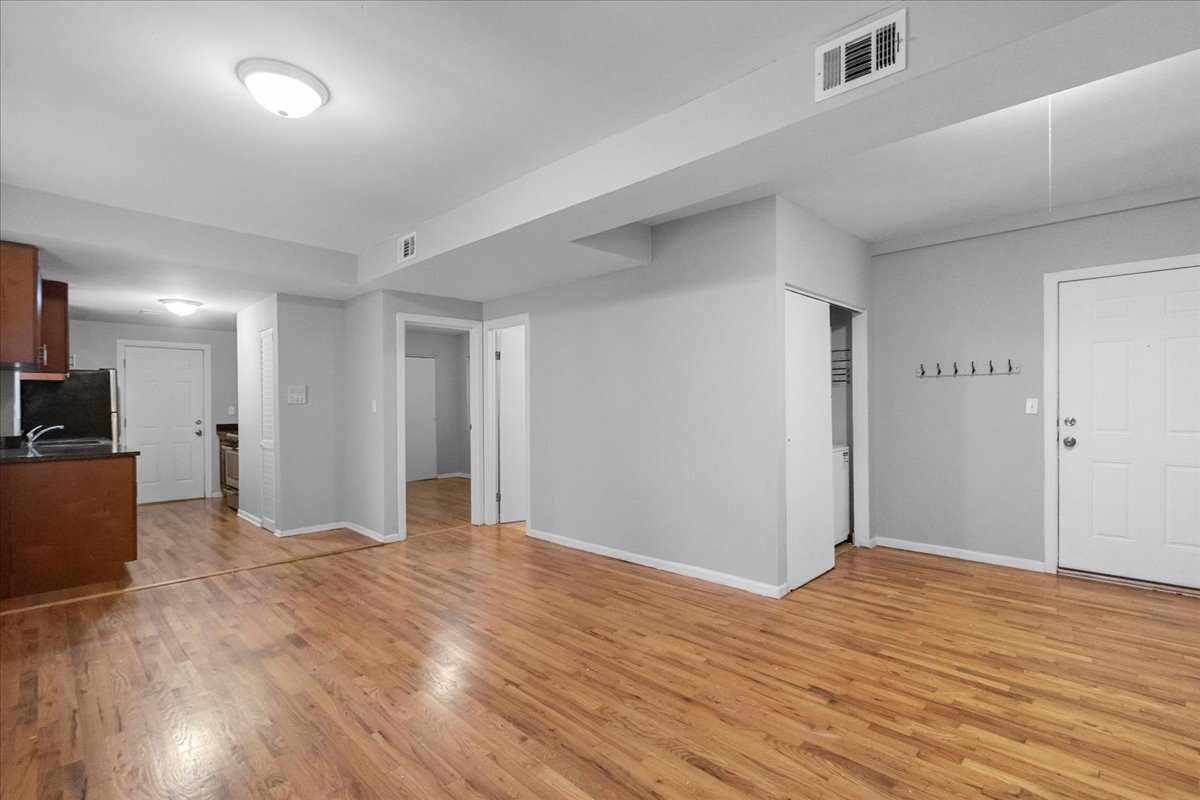 1464 West Ohio Street, Unit 1F Chicago, IL 60642 - Photo 6 of 10 a view of a big room with wooden floor and a kitchen