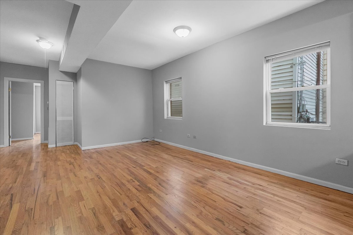 1464 West Ohio Street, Unit 1F Chicago, IL 60642 - Photo 8 of 10 a view of empty room with wooden floor and fan