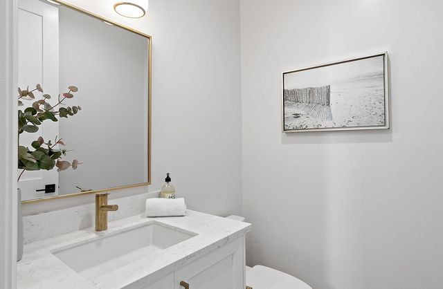 a bathroom with a sink a toilet and mirror