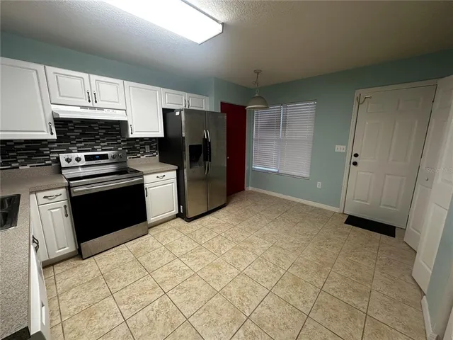 a kitchen with stainless steel appliances granite countertop a stove a sink and a refrigerator