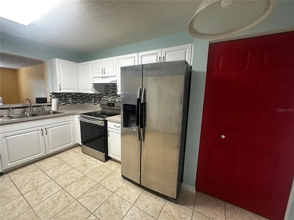 a kitchen with a refrigerator sink and cabinets
