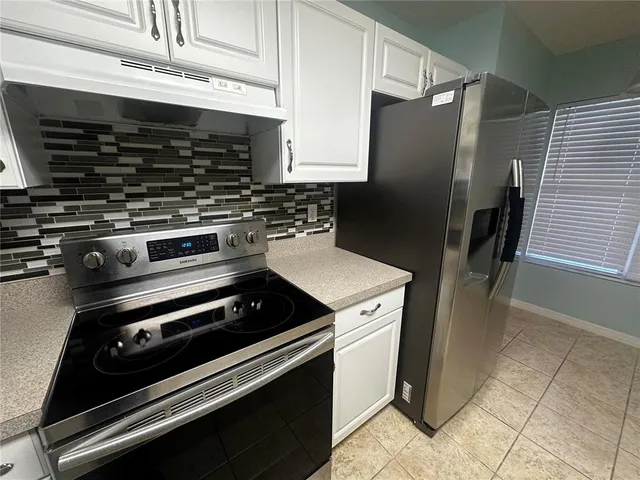 a kitchen with granite countertop a stainless steel stove and refrigerator