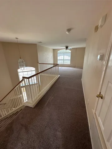 a view of staircase with lots of frames on wall and a window