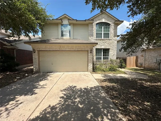 a front view of a house with a yard and garage