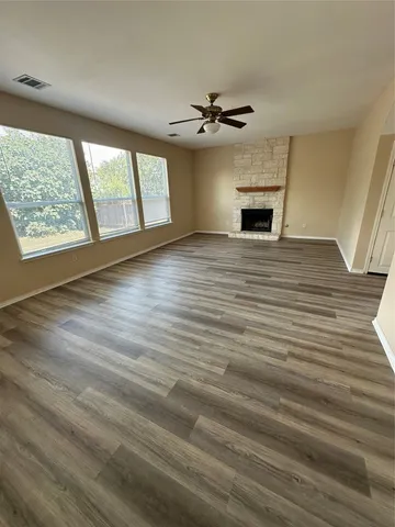 a view of an empty room with a window and fireplace