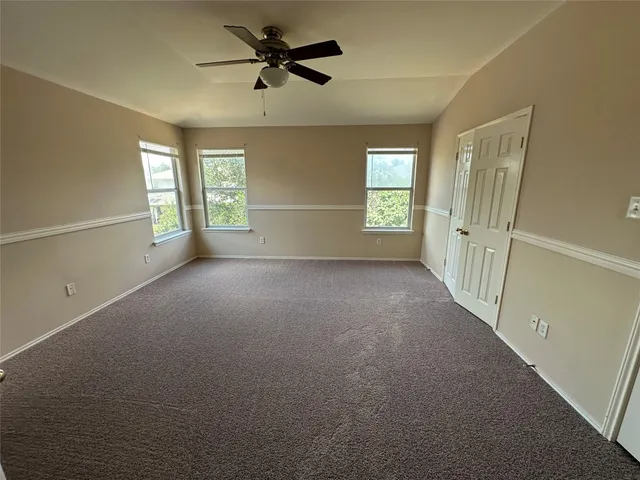 a view of a livingroom with a ceiling fan and window