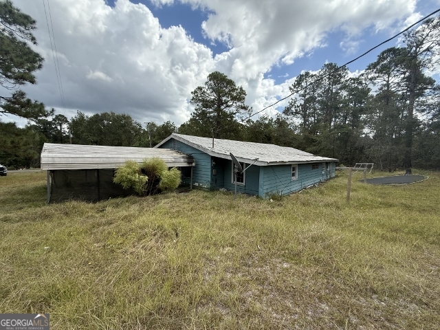 150 Kemp Road Swainsboro, GA 30401 - Photo 11 of 18 a view of a house with a yard potted plants and a large tree