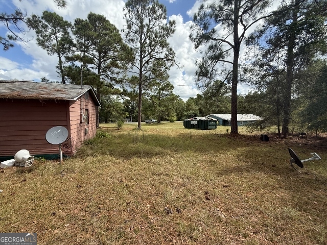 150 Kemp Road Swainsboro, GA 30401 - Photo 13 of 18 a backyard of a house with barbeque oven table and chairs