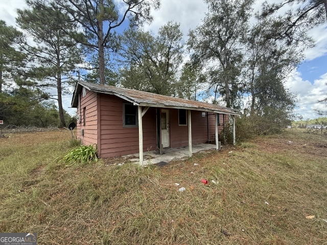 150 Kemp Road Swainsboro, GA 30401 - Photo 2 of 18 a backyard of a house with large trees and brick wall