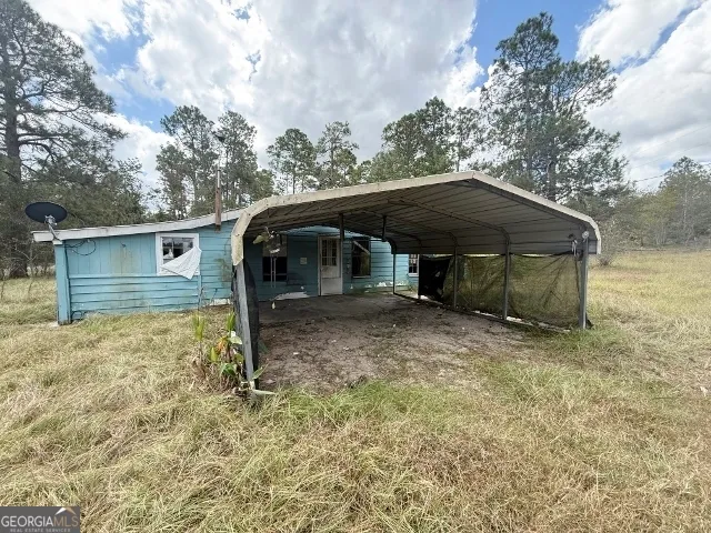 a view of a house with backyard and trees