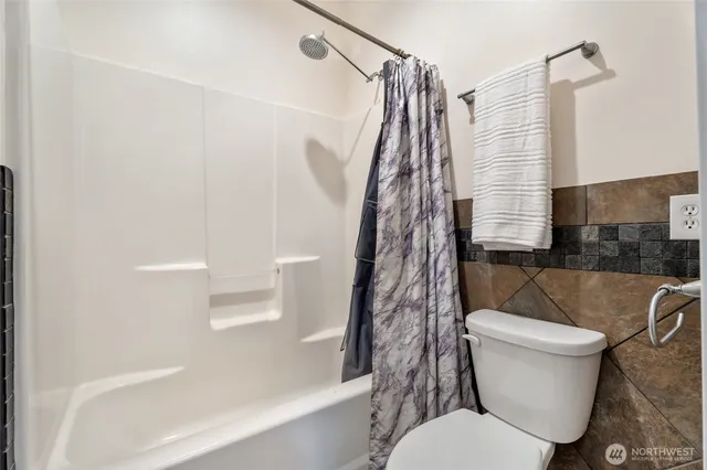 a bedroom with a bed and a flat tv screen on a dresser