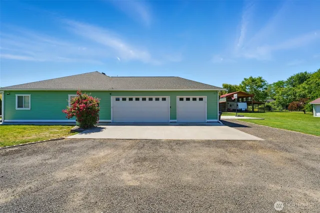 a view of a house with backyard and a tree