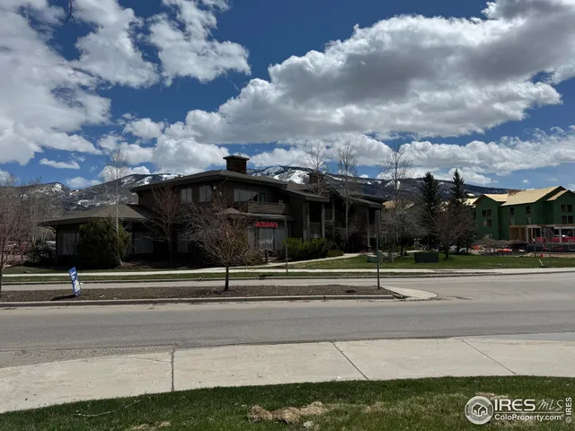 a front view of a building with lots of trees