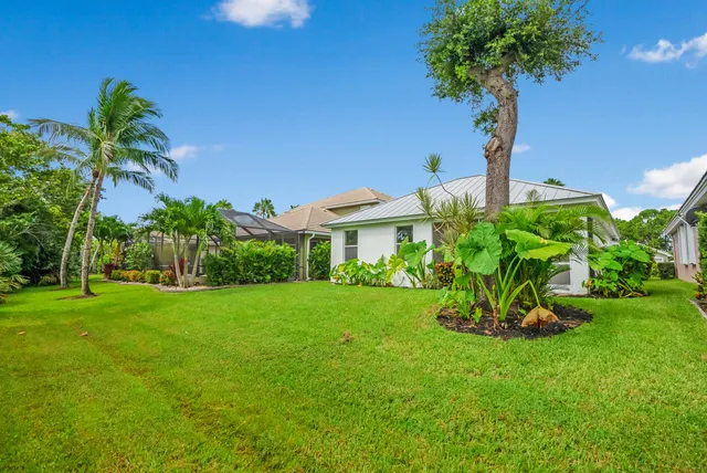 a view of a garden with a tree in front of the house