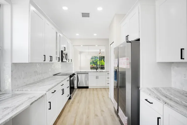 a view of a kitchen with a sink and refrigerator