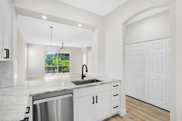 a kitchen with stainless steel appliances granite countertop a sink and a window