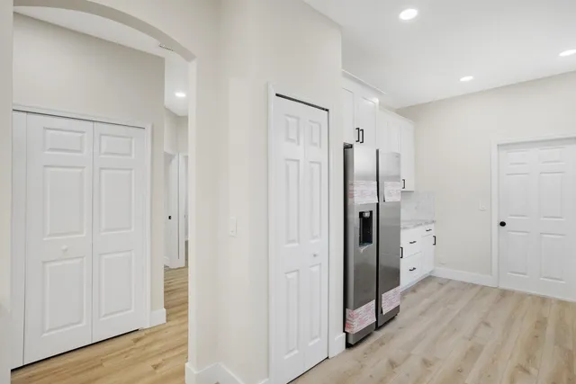 a view of an empty room with wooden floor and windows
