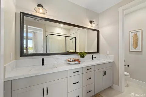 a bathroom with double vanity sinks and a mirror