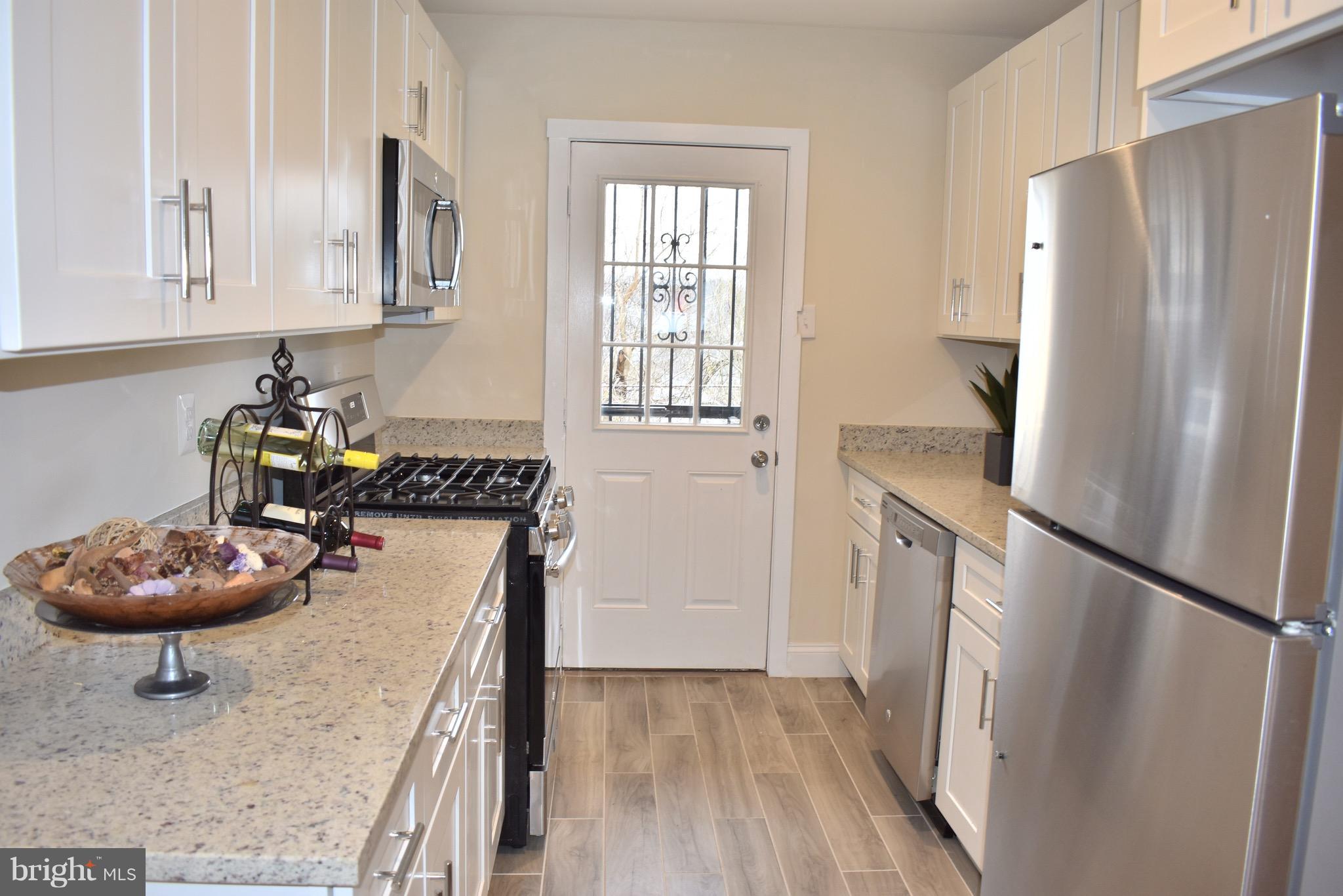 7733 Oxman Road Landover, MD 20785 - Photo 12 of 19 a kitchen with stainless steel appliances granite countertop a refrigerator and a sink