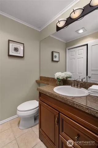 a bathroom with a granite countertop toilet sink and mirror