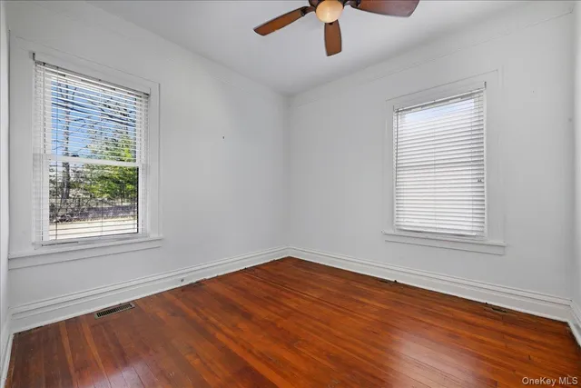 an empty room with a window and wooden floor