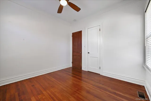 an empty room with wooden floor and closet