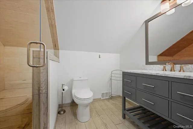 a bathroom with a toilet a sink and mirror
