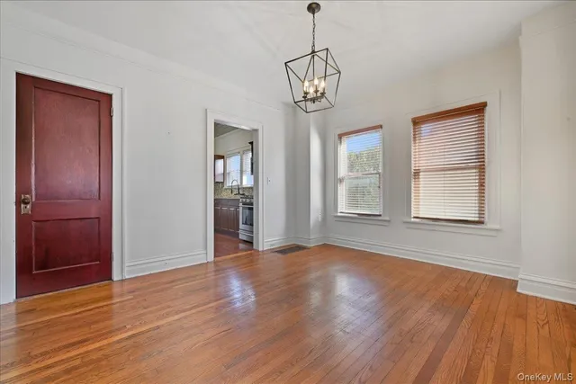 a view of empty room with wooden floor and window