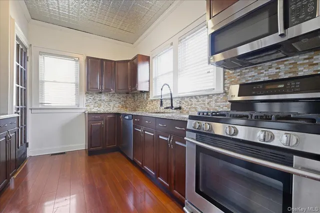 a kitchen with stainless steel appliances granite countertop a stove a sink and a microwave