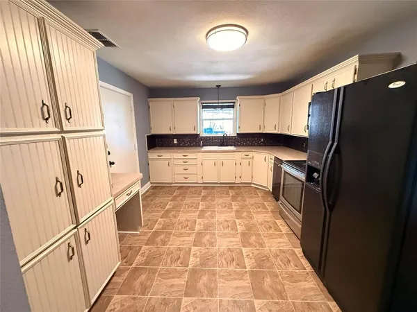 a kitchen with stainless steel appliances granite countertop a refrigerator and a stove