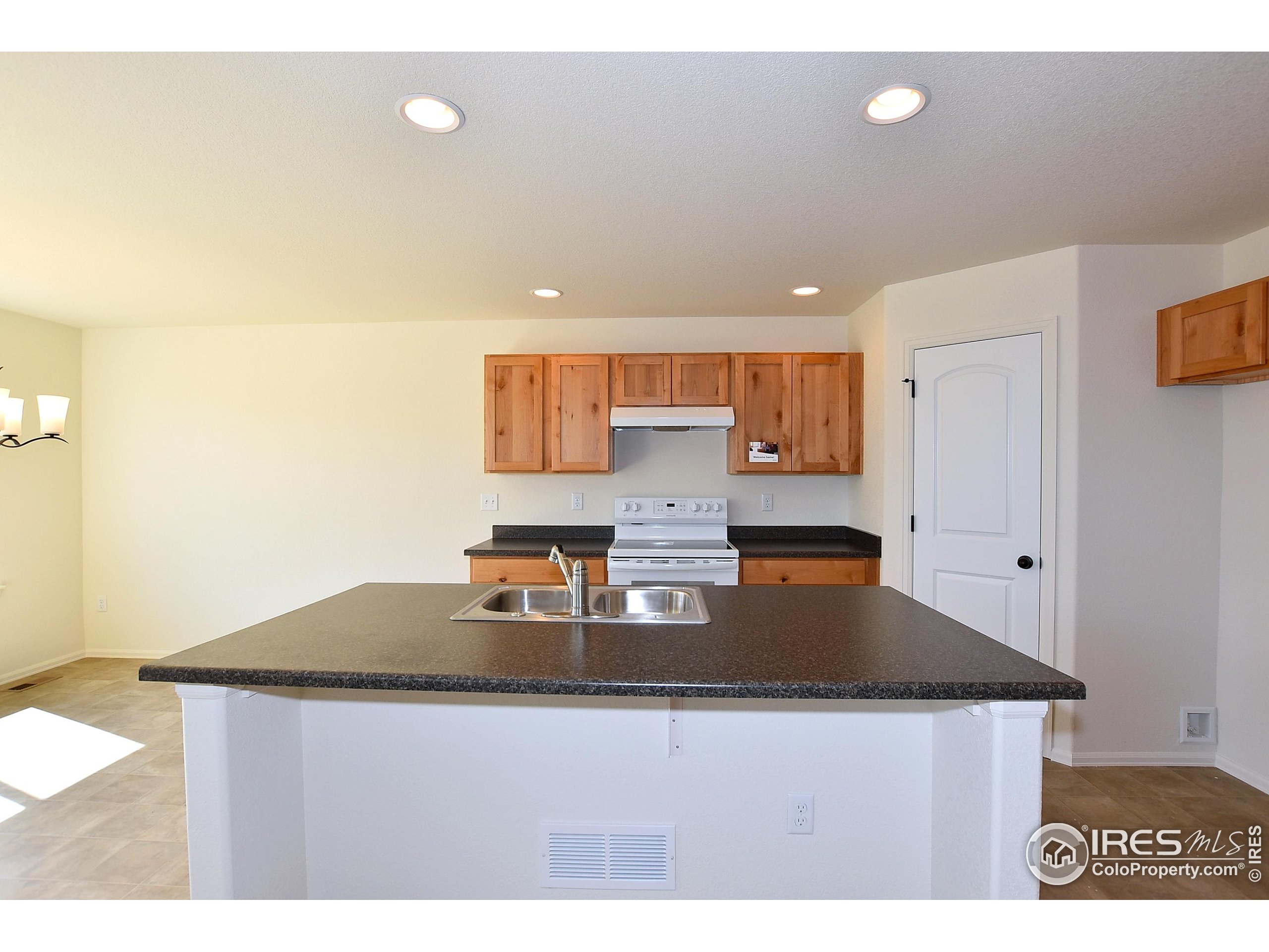 620 87th Avenue Greeley, CO 80634 - Photo 15 of 39 a kitchen with kitchen island granite countertop a sink a stove and a refrigerator