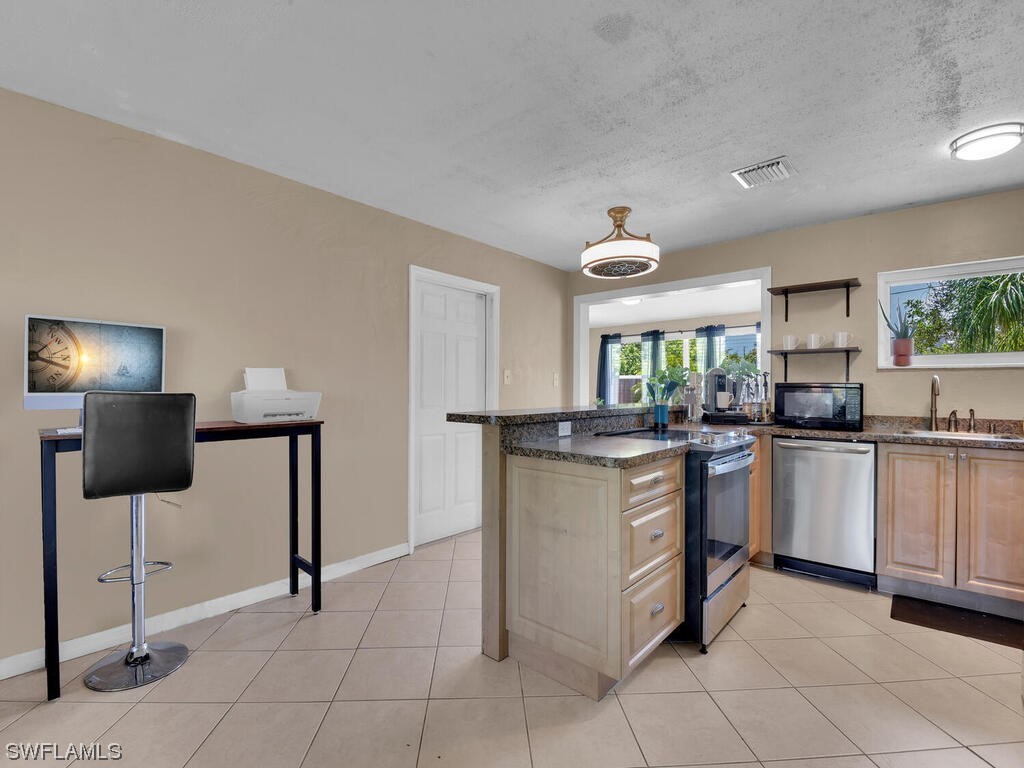 26499 Eager Road Punta Gorda, FL 33955 - Photo 13 of 21 a kitchen with stainless steel appliances granite countertop a sink and a refrigerator