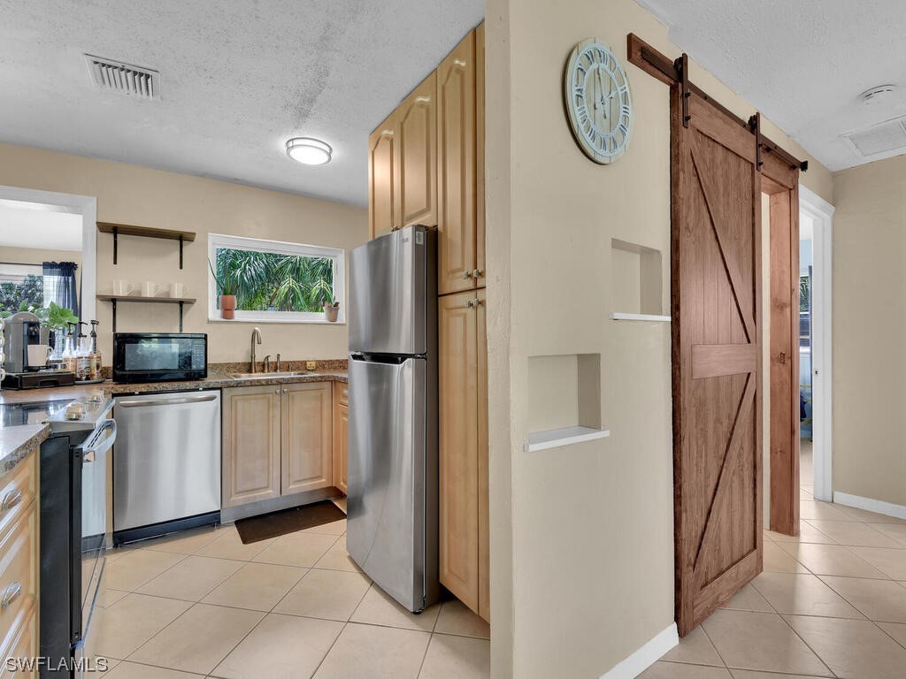 26499 Eager Road Punta Gorda, FL 33955 - Photo 15 of 21 a kitchen with white cabinets and stainless steel appliances