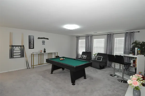 a room with furniture pool table and windows